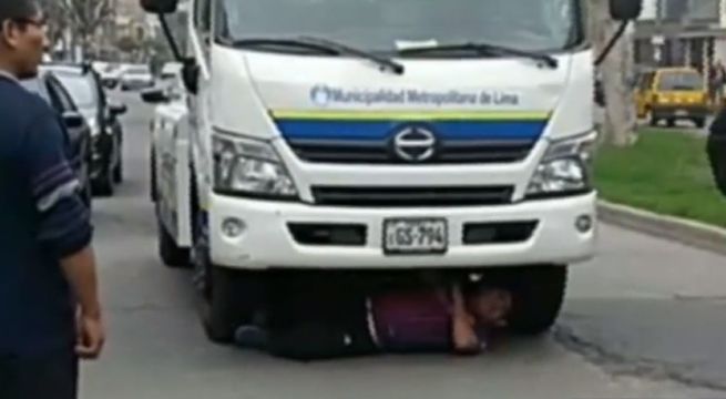 Colectivero se metió debajo de grúa para evitar que se lleven su vehículo