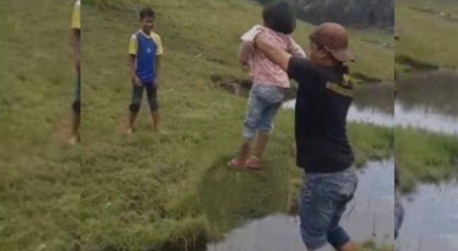Hace cruzar a su hija un arroyo sin que se moje pero él no corre con la misma suerte (Video)